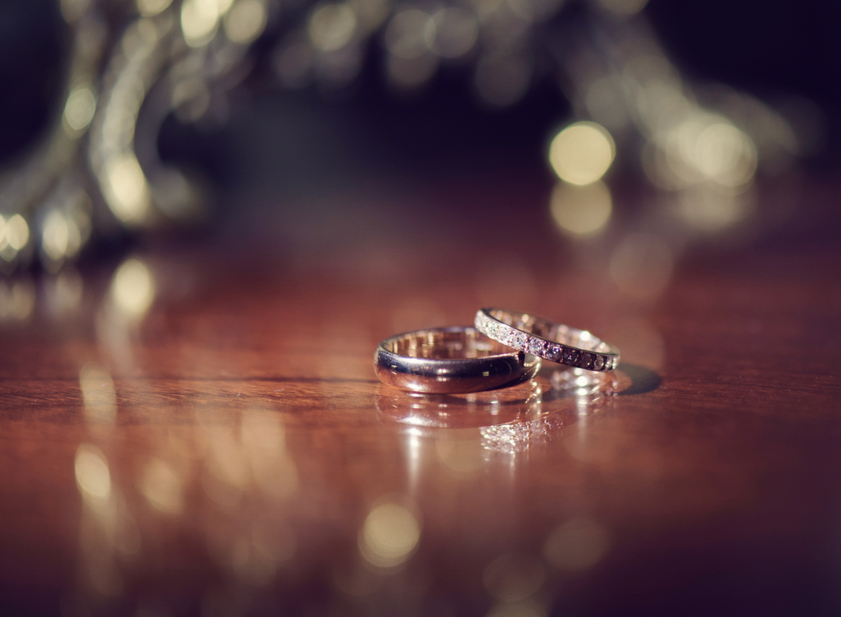 A pair of wedding rings resting on wood.