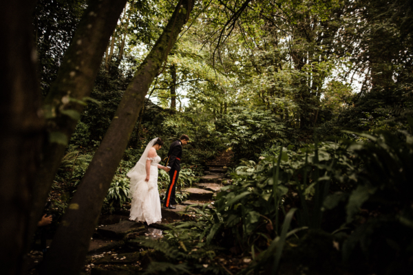Wedding couple walking through castle garden