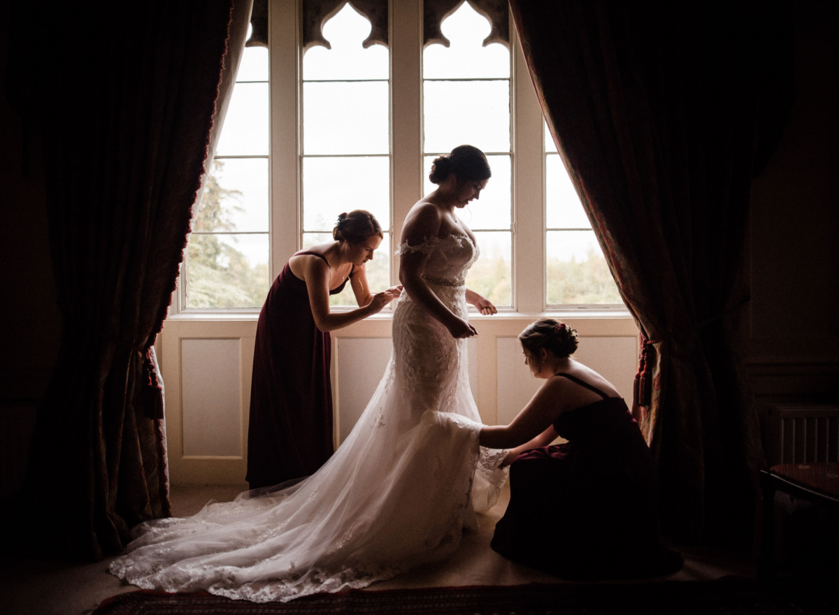Bride and two bridesmaids in front of a large window