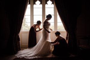 Bride and two bridesmaids in front of a large window