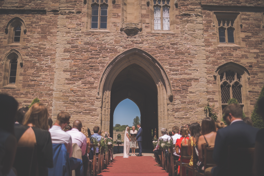 A couple getting married in the archway entrance to Hampton Court CastlePhoto by Rebecca Fulton Photography