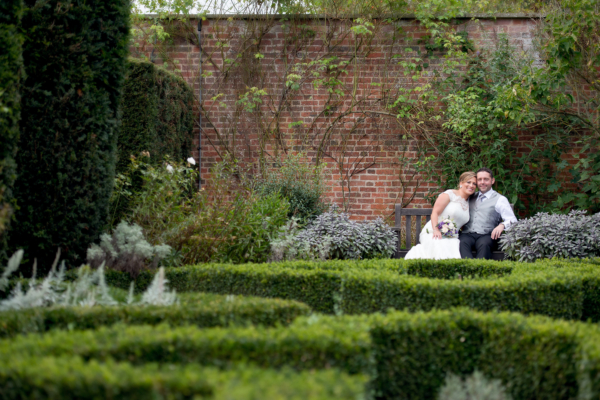 Couple on a bench in walled garden with box hedges