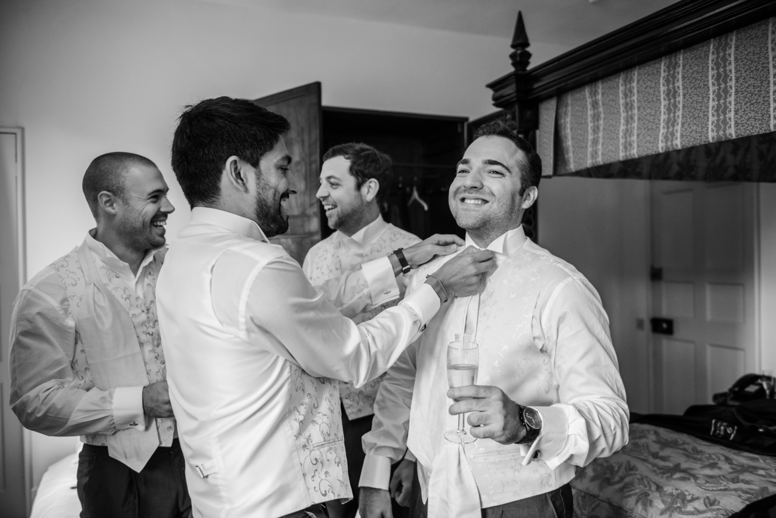 A group of men laughing, preparing for a wedding