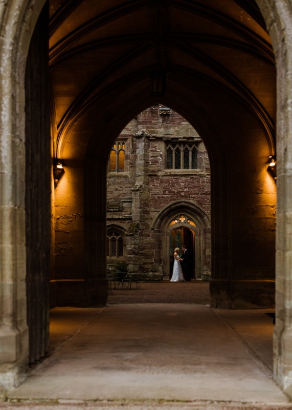 Couple standing in amber lit archway