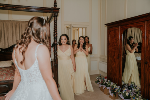 Bridesmaids see the bride in dress for first time