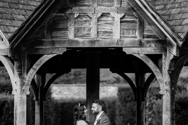 Wedding couple embrace on the pavilion in black and white