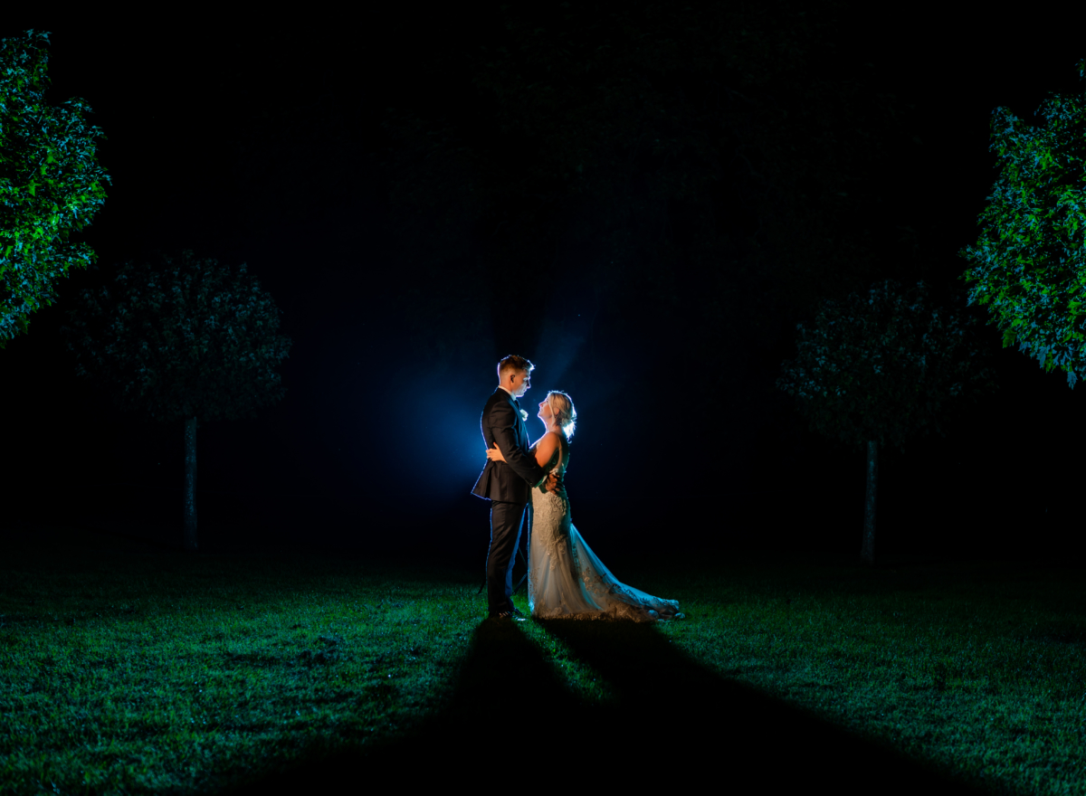 Couple stand together in dark for photo