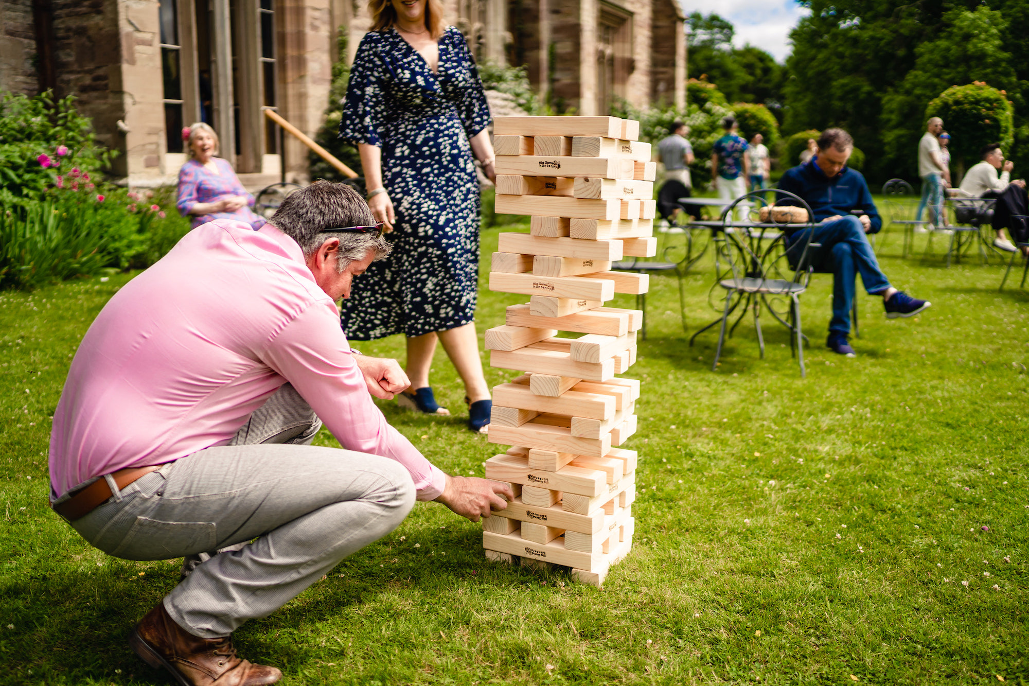 guest playing giant Jenga on South Lawn at Hampton Court castle wedding