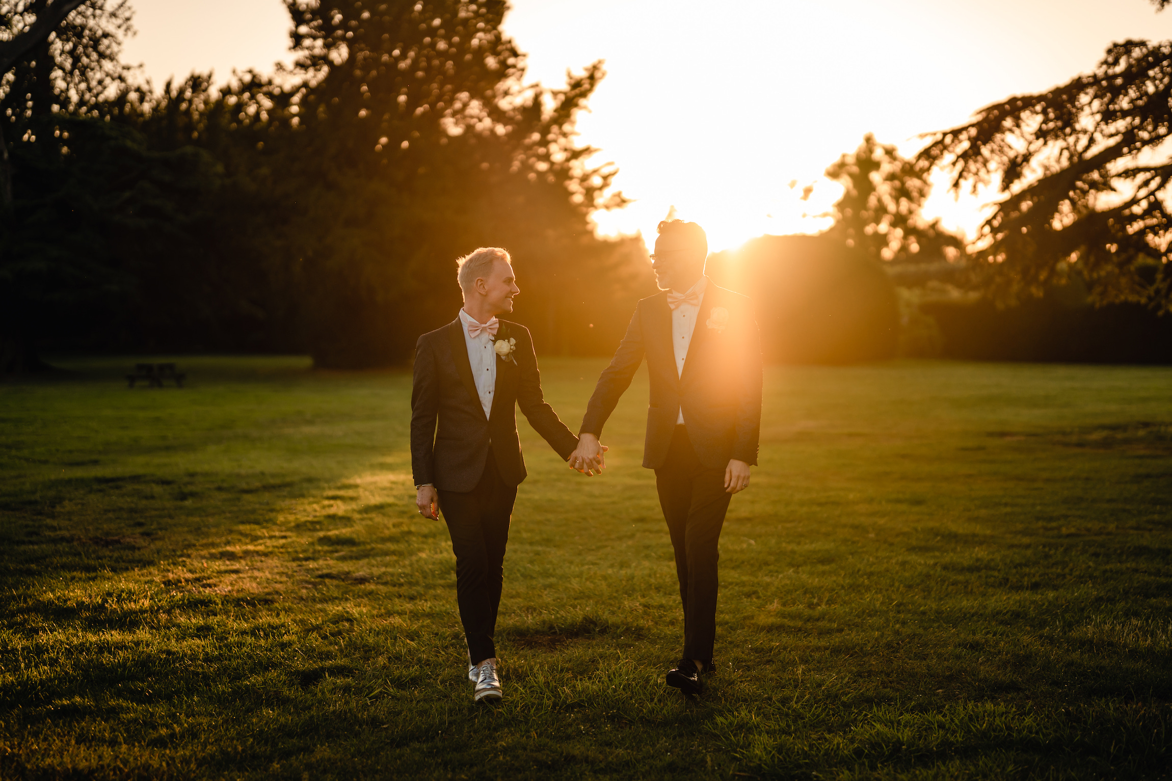 grooms walking in golden hour light at Hampton Court castle wedding